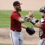 Arizona Diamondbacks relief pitcher Archie Bradley, left, celebrates with catcher Stephen Vogt after retiring Colorado Rockies' Trevor Story for the final out in the ninth inning of a baseball game Wednesday, Aug. 12, 2020, in Denver. Arizona won 13-7. (AP Photo/David Zalubowski)