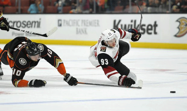 Anaheim Ducks right wing Corey Perry, left, and Arizona Coyotes center Lane Pederson fall as they b...
