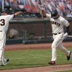 San Francisco Giants' Alex Dickerson, right, is congratulated by third base coach Ron Wotus after hitting a three-run home run during the seventh inning of a baseball game against the Arizona Diamondbacks in San Francisco, Sunday, Aug. 23, 2020. (AP Photo/Jeff Chiu)