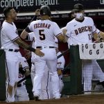 Arizona Diamondbacks Eduardo Escobar (5) celebrates with manager Torey Lovullo, right, and David Peralta, left, after scoring on a base hit by teammate Carson Kelly during the sixth inning of a baseball game against the Oakland Athletics Monday, Aug. 17, 2020, in Phoenix. (AP Photo/Matt York)
