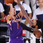 Phoenix Suns' Devin Booker shoots the game-winning basket over Los Angeles Clippers' Paul George in an NBA basketball game Tuesday, Aug. 4, 2020, in Lake Buena Vista, Fla. (Kevin C. Cox/Pool Photo via AP)