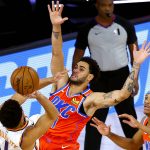 Phoenix Suns' Devin Booker, left, tries to shoot past Oklahoma City Thunder's Abdel Nader, center, during the first half of an NBA basketball game Monday, Aug. 10, 2020, in Lake Buena Vista, Fla. (Mike Ehrmann/Pool Photo via AP)
