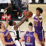Los Angeles Clippers' Lou Williams grabs a rebound between Phoenix Suns' Dario Saric (20), Cameron Johnson (23) and Frank Kaminsky (8) during the first half of an NBA basketball game Tuesday, Aug. 4, 2020, in Lake Buena Vista, Fla. (Kevin C. Cox/Pool Photo via AP)