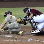 San Diego Padres' Jake Cronenworth, left is tagged out by Arizona Diamondbacks catcher Stephen Vogt while trying to score in the sixth inning during a baseball game, Sunday, Aug 16, 2020, in Phoenix. (AP Photo/Rick Scuteri)