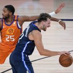 Dallas Mavericks' Luka Doncic, right, passes Phoenix Suns' Mikal Bridges (25) during the first half of an NBA basketball game Thursday, Aug. 13, 2020 in Lake Buena Vista, Fla. (AP Photo/Ashley Landis, Pool)