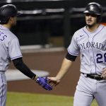 Colorado Rockies' Nolan Arenado (28) is greeted by Josh Fuentes (8) after scoring on a base hit by Matt Kemp during the first inning of a baseball game, Tuesday, Aug. 25, 2020, in Phoenix. (AP Photo/Matt York)