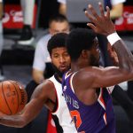 Los Angeles Clippers' Paul George, left, makes a pass around Phoenix Suns' Deandre Ayton during an NBA basketball game Tuesday, Aug. 4, 2020, in Lake Buena Vista, Fla. (Kevin C. Cox/Pool Photo via AP)
