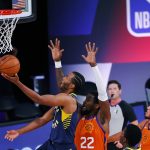 Indiana Pacers' T.J. Warren, left, attacks the basket as Phoenix Suns' Deandre Ayton (22) defends during the first half of an NBA basketball game Thursday, Aug. 6, 2020, in Lake Buena Vista, Fla. (Kevin C. Cox/Pool Photo via AP)