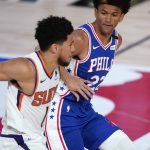 Phoenix Suns guard Devin Booker (1) tries to get by Philadelphia 76ers guard Matisse Thybulle (22) during the second half of an NBA basketball game Tuesday, Aug. 11, 2020, in Lake Buena Vista, Fla. (AP Photo/Ashley Landis, Pool)