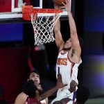 Phoenix Suns' Devin Booker (1) dunks as Miami Heat's Derrick Jones Jr. (5) defends during the first half of an NBA basketball game, Saturday, Aug. 8, 2020 in Lake Buena Vista, Fla. (AP Photo/Ashley Landis, Pool)