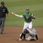 
              Oakland Athletics' Chad Pinder throws over Arizona Diamondbacks' Tim Locastro to complete a double play in the first inning of a baseball game Thursday, Aug. 20, 2020, in Oakland, Calif. Arizona's Ketel Marte was out at first base. (AP Photo/Ben Margot)
            