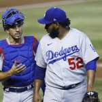 Los Angeles Dodgers catcher Austin Barnes, left, talks with Dodgers relief pitcher Pedro Baez (52) as the two walk off the field after the final out against the Arizona Diamondbacks during the seventh inning of a baseball game Sunday, Aug. 2, 2020, in Phoenix. (AP Photo/Ross D. Franklin)