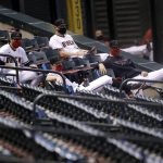 Arizona Diamondbacks players sit in the stands during the first inning of a baseball game against the Houston Astros Thursday, Aug. 6, 2020, in Phoenix. (AP Photo/Matt York)