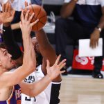 Phoenix Suns' Dario Saric, left, takes a shot against Los Angeles Clippers' Patrick Patterson during an NBA basketball game Tuesday, Aug. 4, 2020, in Lake Buena Vista, Fla. (Kevin C. Cox/Pool Photo via AP)