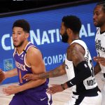 Phoenix Suns Devin Booker (1) drives against Los Angeles Clippers Marcus Morris Sr. (31) and Kawhi Leonard (2) during the first half of an NBA basketball game Tuesday, Aug. 4, 2020, in Lake Buena Vista, Fla. (Kevin C. Cox/Pool Photo via AP)