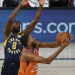 Phoenix Suns' Mikal Bridges (25) drives to the basket as Indiana Pacers' Justin Holiday (8) defends during the first half of an NBA basketball game Thursday, Aug. 6, 2020, in Lake Buena Vista, Fla. (Kevin C. Cox/Pool Photo via AP)