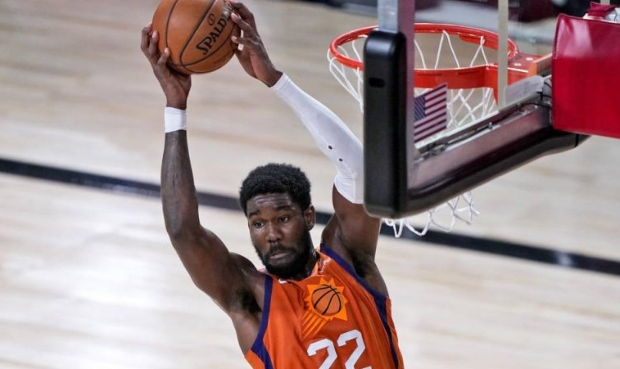 Phoenix Suns' Deandre Ayton (22) grabs the ball during the first half of an NBA basketball game aga...