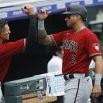 Arizona Diamondbacks' David Peralta, right, is congratulated by Nick Ahmed as Peralta heads to the dugout during a pitching change following his double to drive in three runs off Colorado Rockies relief pitcher Tyler Kinley in the seventh inning of a baseball game Wednesday, Aug. 12, 2020, in Denver. (AP Photo/David Zalubowski)