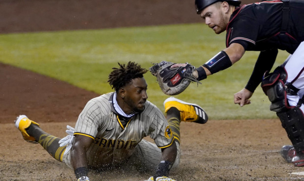 San Diego Padres' Jorge Mateo is tagged out by Arizona Diamondbacks catcher Carson Kelly for the fi...
