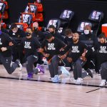 The Phoenix Suns team take a knee during the national anthem prior to the start of an NBA basketball game against the Indiana Pacers Thursday, Aug. 6, 2020, in Lake Buena Vista, Fla. (Kevin C. Cox/Pool Photo via AP)