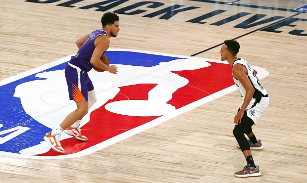 Los Angeles Clippers' Landry Shamet, right, defends Phoenix Suns' Devin Booker during an NBA basket...