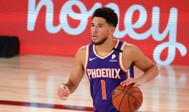 Phoenix Suns' Devin Booker dribbles against the Los Angeles Clippers during an NBA basketball game ...