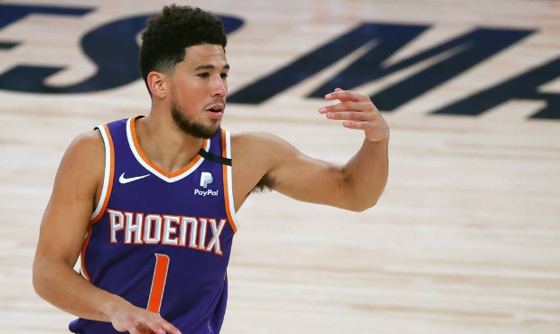 Phoenix Suns' Devin Booker directs his teammates during an NBA basketball game against the Los Ange...