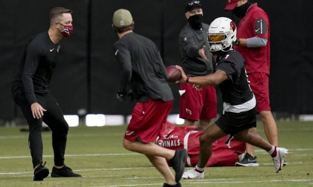 Arizona Cardinals quarterback Kyler Murray (1) tosses the ball to a coach as head coach Kliff Kings...