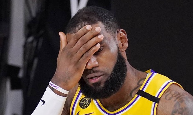 Los Angeles Lakers' LeBron James wipes his face after being fouled during the second half of an NBA...