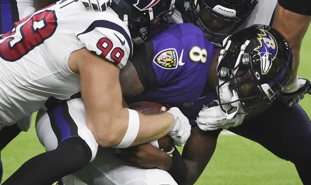 Baltimore Ravens quarterback Lamar Jackson (8) is sacked by Houston Texans defensive end J.J. Watt ...