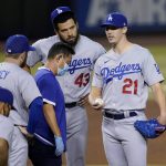 Los Angeles Dodgers starting pitcher Walker Buehler (21) is checked by the trainer during the third inning of a baseball game against the Arizona Diamondbacks, Tuesday, Sept. 8, 2020, in Phoenix. (AP Photo/Matt York)