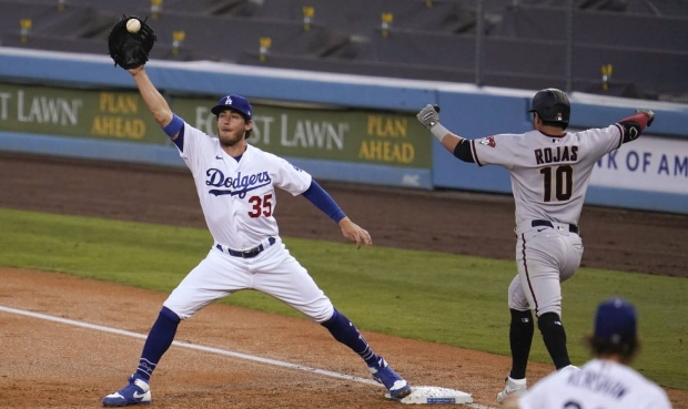 Los Angeles Dodgers starting pitcher Clayton Kershaw, bottom right, throws to first baseman Cody Be...