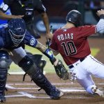 Arizona Diamondbacks' Josh Rojas, right, slides around the tag by Seattle Mariners catcher Joseph Odom, left, to score a run during the first inning of a baseball game Sunday, Sept. 13, 2020, in Phoenix. (AP Photo/Ross D. Franklin)