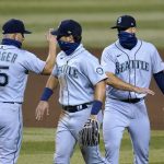 Seattle Mariners third baseman Kyle Seager (15), second baseman Dylan Moore, middle, and first baseman Evan White celebrate after a baseball game against the Arizona Diamondbacks on Saturday, Sept. 12, 2020, in Phoenix. The Mariners won 7-3. (AP Photo/Ross D. Franklin)