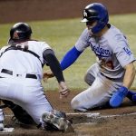 Los Angeles Dodgers' Enrique Hernandez, right, is tagged out trying to steal home by Arizona Diamondbacks catcher Carson Kelly during the sixth inning of a baseball game against the Arizona Diamondbacks, Thursday, Sept. 10, 2020, in Phoenix. (AP Photo/Matt York)