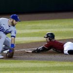 Arizona Diamondbacks' Tim Locastro slides safely into third base with an RBI triple as Los Angeles Dodgers third baseman Max Muncy makes a catch on a late throw during the second inning of a baseball game Wednesday, Sept. 9, 2020, in Phoenix. (AP Photo/Ross D. Franklin)