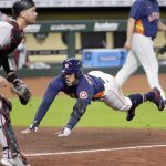 
              Houston Astros George Springer, right, dives for home plate on his inside the park home run as Arizona Diamondbacks catcher Carson Kelly, left, waits for the ball during the sixth inning of a baseball game Sunday, Sept. 20, 2020, in Houston. (AP Photo/Michael Wyke)
            