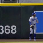 Los Angeles Dodgers' Chris Taylor looks away as a home run ball hit by Arizona Diamondbacks' Kole Calhoun rolls above the fence during the third inning of a baseball game, Tuesday, Sept. 8, 2020, in Phoenix. (AP Photo/Matt York)