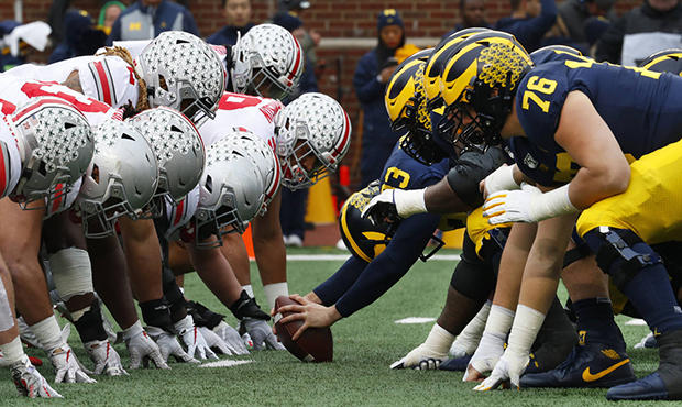 FILE- In this Nov. 30, 2019, file photo, Ohio State, left, and Michigan players line up at the line...