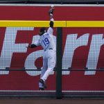 Colorado Rockies right fielder Charlie Blackmon leaps in vain for an RBI triple by Arizona Diamondbacks' Eduardo Escobar during the third inning of the first game of a baseball doubleheader Friday, Sept. 25, 2020, in Phoenix. (AP Photo/Ross D. Franklin)