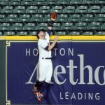 Houston Astros right fielder Josh Reddick reaches for a home run by Arizona Diamondbacks' Kole Calhoun during the eighth inning of a baseball game Friday, Sept. 18, 2020, in Houston. (AP Photo/David J. Phillip)