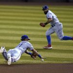 Texas Rangers shortstop Anderson Tejeda, left, dives in vain for a single hit by Arizona Diamondbacks' Daulton Varsho, as second baseman Rougned Odor, right, runs to back the play up during the eighth inning of a baseball game Tuesday, Sept. 22, 2020, in Phoenix. The Diamondbacks won 7-0. (AP Photo/Ross D. Franklin)