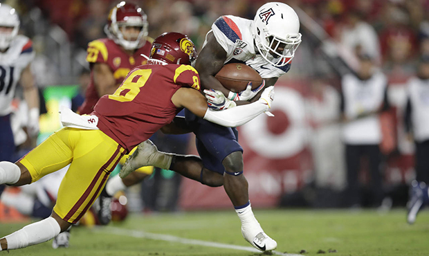 Arizona running back J.J. Taylor, right, is tackled by Southern California cornerback Chris Steele ...