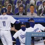 Los Angeles Dodgers' A.J. Pollock (11) is greeted by manager Dave Roberts, center, and bench coach Bob Geren after Pollock's solo home run during the seventh inning of the team's baseball game against the Arizona Diamondbacks on Thursday, Sept. 3, 2020, in Los Angeles. (AP Photo/Marcio Jose Sanchez)