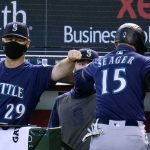 Seattle Mariners' Kyle Seager (15) celebrates his run scored against the Arizona Diamondbacks with manager Scott Servais (29) and assistant hitting coach Jarret DeHart, center, during the first inning of a baseball game Sunday, Sept. 13, 2020, in Phoenix. (AP Photo/Ross D. Franklin)