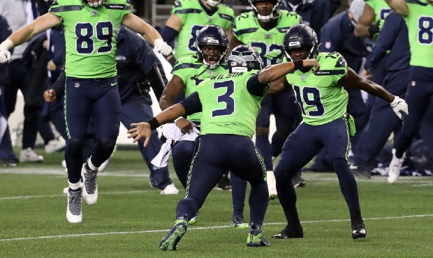 Russell Wilson #3 of the Seattle Seahawks celebrates with his teammates after scoring the game-winn...