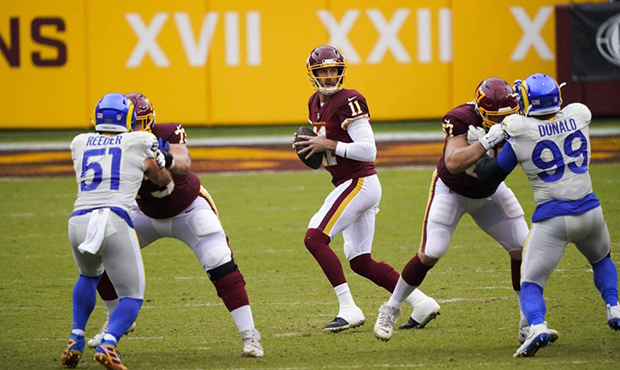 Washington Football Team's Alex Smith drops back to pass during the first half of an NFL football g...