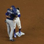 Los Angeles Dodgers' Mookie Betts gets a hug from Tampa Bay Rays shortstop Willy Adames after stealing second during the fifth inning in Game 1 of the baseball World Series Tuesday, Oct. 20, 2020, in Arlington, Texas. (AP Photo/David J. Phillip)