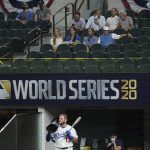 Fans watch as Los Angeles Dodgers' Max Muncy gets ready to bat against the Tampa Bay Rays during the fourth inning in Game 1 of the baseball World Series Tuesday, Oct. 20, 2020, in Arlington, Texas. (AP Photo/Tony Gutierrez)