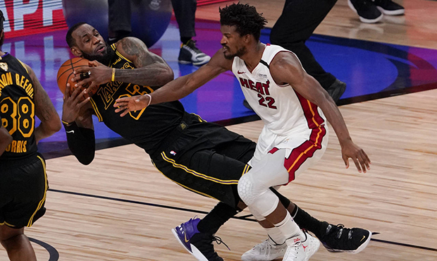 Los Angeles Lakers forward LeBron James pulls rebound away from Miami Heat forward Jimmy Butler dur...